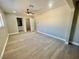 Open floor plan bedroom features new light fixture, light grey walls, and wood-look flooring at 619 Brush St, Las Vegas, NV 89107