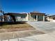 Single-story home featuring a concrete driveway, minimalistic landscaping and a neutral exterior at 619 Brush St, Las Vegas, NV 89107