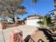 House exterior with a driveway, brick fence, and mature tree at 6402 Agua Dr, Las Vegas, NV 89103