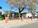 House exterior with brick wall, landscaping, and a large tree in the front yard at 6402 Agua Dr, Las Vegas, NV 89103