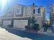 Tan three-story townhome with two-car garage and landscaping at 939 Paisley St, Las Vegas, NV 89145