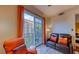 Living area with orange chair and brown couch, view of balcony and city at , Las Vegas, NV 89123