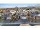 Aerial view of three-story homes with mountain views and solar panels at 10409 Mont Pourri Ct, Las Vegas, NV 89149