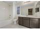 Clean bathroom with tub, toilet and dark brown vanity at 10409 Mont Pourri Ct, Las Vegas, NV 89149