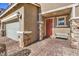 Inviting entryway with orange door, stone accents, and a bench at 10640 Skye Scout Ave, Las Vegas, NV 89166