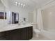 Clean bathroom with dark vanity, bathtub, and large mirror at 10779 Crown Ct, Las Vegas, NV 89141