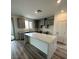Spacious kitchen featuring gray cabinets, an island, and wood flooring at 1521 Bat Hawk St, Las Vegas, NV 89138