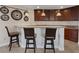 Well-equipped basement bar with granite countertop and dark wood cabinets at 20 Via Mantova # 309, Henderson, NV 89011