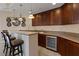 Basement bar featuring wine cooler, granite counters & wood cabinets at 20 Via Mantova # 309, Henderson, NV 89011