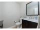 Modern bathroom with dark vanity, a toilet, and a large mirror at 2000 Catalina Marie Ave, Henderson, NV 89074