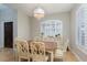 Formal dining room with a wooden table, white chairs, and plantation shutters at 2000 Catalina Marie Ave, Henderson, NV 89074