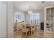 Formal dining room with a wooden table, white chairs, and plantation shutters at 2000 Catalina Marie Ave, Henderson, NV 89074