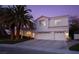 Two-story house with white exterior, palm trees, and a three-car garage at dusk at 2000 Catalina Marie Ave, Henderson, NV 89074