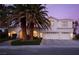 Two-story house with white exterior, palm trees, and a three-car garage at dusk at 2000 Catalina Marie Ave, Henderson, NV 89074