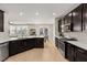 Modern kitchen featuring dark cabinetry, expansive island, and stainless steel appliances at 2124 Danzinger Pl, Henderson, NV 89044