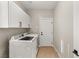 Bright laundry room with washer, dryer, and upper cabinets at 2124 Danzinger Pl, Henderson, NV 89044