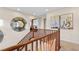 Upstairs hallway with hardwood railing, artwork, and a view to an office at 2130 Maderno St, Henderson, NV 89044