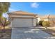 Frontal view of the garage and driveway showcases desert landscaping and a tile roof at 2255 Potter Lake Ave, Henderson, NV 89052