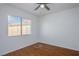 Well-lit bedroom with wood floors, ceiling fan, and a window providing natural light and neighborhood views at 3335 Cheltenham St, Las Vegas, NV 89129