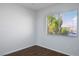 Cozy bedroom with wood-look floors and a window with blinds offering neighborhood views at 3335 Cheltenham St, Las Vegas, NV 89129