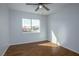 Sunlit bedroom featuring wood-look floors, a ceiling fan, and a window with neighborhood views at 3335 Cheltenham St, Las Vegas, NV 89129