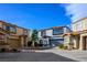 Townhome exteriors in a community setting with a shared driveway and blue skies at 3335 Cheltenham St, Las Vegas, NV 89129