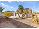 Home's backyard features a large patio, palm trees, and gravel at 433 Old Palms Dr, Las Vegas, NV 89123