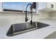 Close-up of a kitchen sink with a modern black faucet and white quartz countertop at 491 Kristin Ln, Henderson, NV 89011