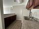 Kitchen with dark wood cabinets, granite countertops, and a double sink at 5181 River Glen Dr # 172, Las Vegas, NV 89103