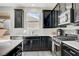 Modern kitchen with dark cabinets, stainless steel appliances and a large window at 6201 Ashley Hills Ave, Las Vegas, NV 89141