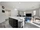 Modern kitchen with island, dark cabinets, and open layout to living room at 6201 Ashley Hills Ave, Las Vegas, NV 89141