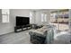 Living room with gray tile floors and sliding glass doors to backyard at 6201 Ashley Hills Ave, Las Vegas, NV 89141