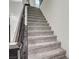 Gray carpeted staircase with dark wood railing at 6201 Ashley Hills Ave, Las Vegas, NV 89141