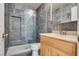 Updated bathroom with gray tile and wood vanity at 6725 Carrera Dr, Las Vegas, NV 89103