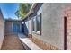 Side yard with gravel pathway, leading to a detached storage unit with blue doors at 6725 Carrera Dr, Las Vegas, NV 89103