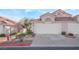 Two-car garage with Spanish style architecture and desert landscaping at 7925 Settlers Ridge Ln, Las Vegas, NV 89145