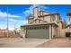 Two-story house with beige siding, green garage door, and driveway at 8101 Spur Ct, Las Vegas, NV 89145