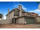 Two-story house with beige siding, green garage door, and landscaping at 8101 Spur Ct, Las Vegas, NV 89145