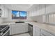 White kitchen with stainless steel appliances and a window at 8101 Spur Ct, Las Vegas, NV 89145