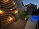 Landscaped backyard with wooden wall and string lights at 8976 Sweet Chestnut Ln, Las Vegas, NV 89178