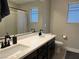 Double vanity bathroom with modern black fixtures and a large mirror at 8976 Sweet Chestnut Ln, Las Vegas, NV 89178