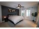 Main bedroom with a king-size bed, dark-colored accent wall, and large windows at 8976 Sweet Chestnut Ln, Las Vegas, NV 89178