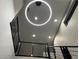 Modern stairwell with circular light fixture and metal railing at 8976 Sweet Chestnut Ln, Las Vegas, NV 89178