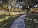 Concrete path runs through a tree-lined area with sprinklers at 9612 World Cup Dr, Las Vegas, NV 89117