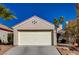 Single story home with a white garage door and desert landscaping at 9612 World Cup Dr, Las Vegas, NV 89117