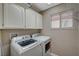 Laundry room with washer, dryer, and upper cabinets at 9612 World Cup Dr, Las Vegas, NV 89117