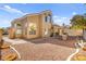 Spacious backyard with gravel landscaping, a built-in grill, and a paved pathway at 9700 Port Orange Ln, Las Vegas, NV 89134