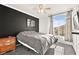 Bedroom with large window, ceiling fan, and dark accent wall at 9700 Port Orange Ln, Las Vegas, NV 89134