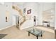 Two-story entryway with tile floors, staircase, and glass-top coffee table at 9700 Port Orange Ln, Las Vegas, NV 89134