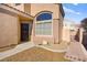 Front entrance with a dark door and a large window, next to a small paved pathway at 9700 Port Orange Ln, Las Vegas, NV 89134